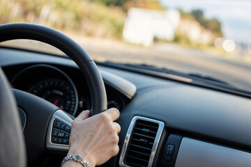 Female hands on the wheel close up