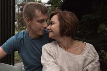 Fototapeta premium mid adult couple in love before kiss sitting outdoors in backyard in summer