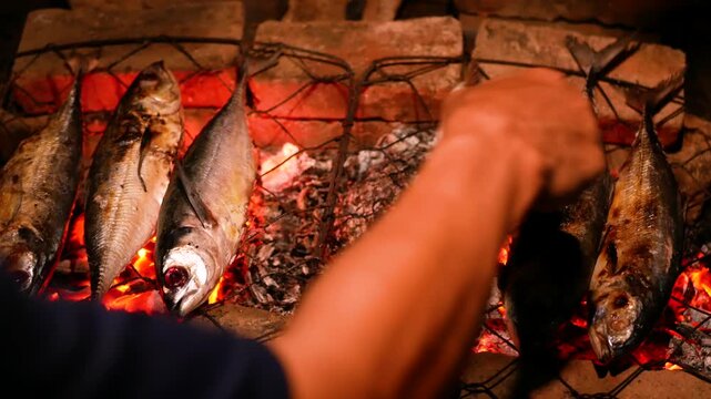 Selective focus of Grilling Cakalang fish or Skipjack tuna (Katsuwonus pelamis) on a cast iron grill. close up view