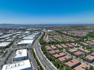 Aerial view of middle class community identical condominium houses next to office zoning, Lake Forest, South California, USA.