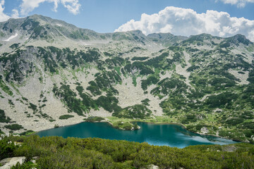 Beautiful mountain lake (Fish Lake) in Pirin Mountains taken in June on a partly cloudy day.