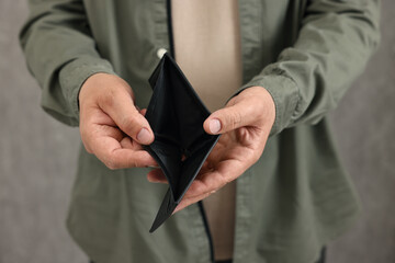 Man with empty wallet on blurred background, closeup