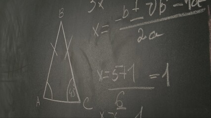 Close up of woman hand writing text and trigonometry formulas on chalkboard, professor writes on blackboard or student solving task. Education and science concept.