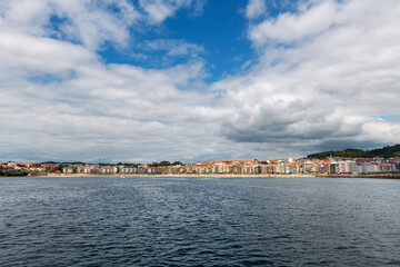 Fototapeta premium Panorama view of Sanxenxo and Silgar beach as seen from the sea on a cloudy Summer day in the Rias Baixas in Galicia, Spain.