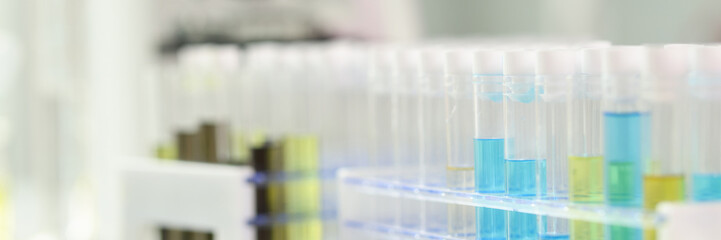 Test tubes with colourful liquid, microscope on background