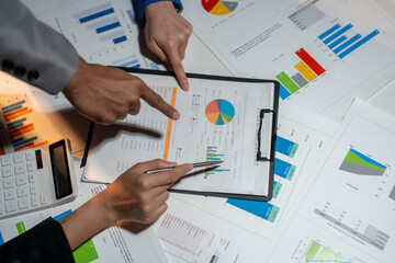 Two people are looking at a chart with a pie chart on it