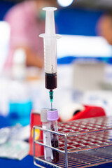 extracting centrifuged blood with a syringe to inject it into a tube for test