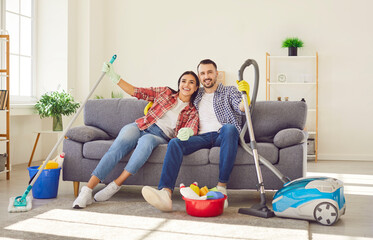 Portrait of happy smiling couple man and woman sitting on sofa in the living room at home with...