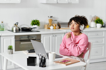 A young woman enjoys her time at home, lost in thought with headphones on.