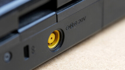 Empty round yellow laptop charging port macro detail closeup, nobody, no people. 20 volts power...