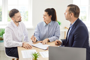 Business people colleagues sitting at the desk on workplace in office discussing new project, reaching agreement and going to sign a contract making a deal. Partnership and teamwork concept.