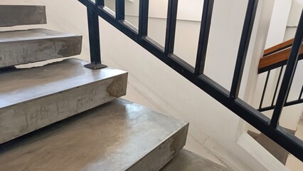 A staircase with a black railing and a white step © Tina