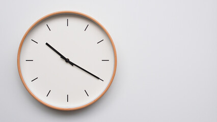 Minimalist wooden Wall Clock on White Wooden Surface with Space for Text – Time Set at 10.20,...