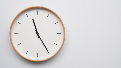 Minimalist wooden Wall Clock on White Wooden Surface with Space for Text – Time Set at 11.25/23.25