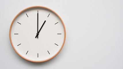 Minimalist wooden Wall Clock on White Wooden Surface with Space for Text – Time Set at 13.00/01.00