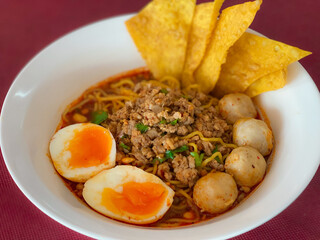 A captivating image of a bowl of noodles, beautifully presented with a variety of fresh ingredients and garnishes. The rich textures and vibrant colors make it an enticing visual for food enthusiasts