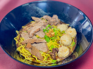 A captivating image of a bowl of noodles, beautifully presented with a variety of fresh ingredients and garnishes. The rich textures and vibrant colors make it an enticing visual for food enthusiasts