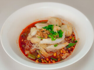 A captivating image of a bowl of noodles, beautifully presented with a variety of fresh ingredients and garnishes. The rich textures and vibrant colors make it an enticing visual for food enthusiasts