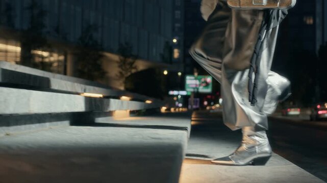 Low section slowmo shot of unrecognizable female superstar wearing fancy silver outfit going up stairs while arriving at celebrity party at night