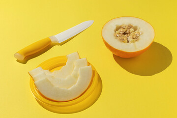 Freshly Sliced Melon With Knife on Vibrant Yellow Background, Healthy Summer Snack Concept
