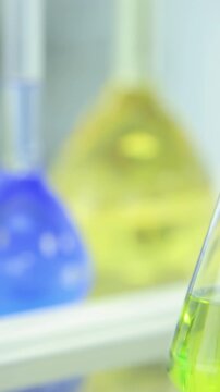 Chemical flasks with green and blue liquid on white background. Test-tubes with colorful chemical reagent. Laboratory glassware. Chemical Laboratory. Selective cocus. Bokeh. scientist and medical
