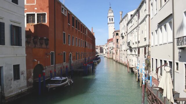 Bateau de la gendarmerie et petit pont sur un canal &agrave; Venise avec un clocher en arri&egrave;re-plan