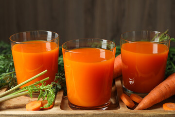 Healthy carrot juice in glasses and fresh vegetables on table