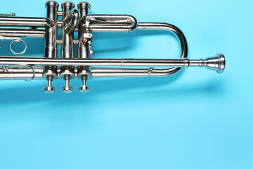 One trumpet on light blue background, top view. Space for text