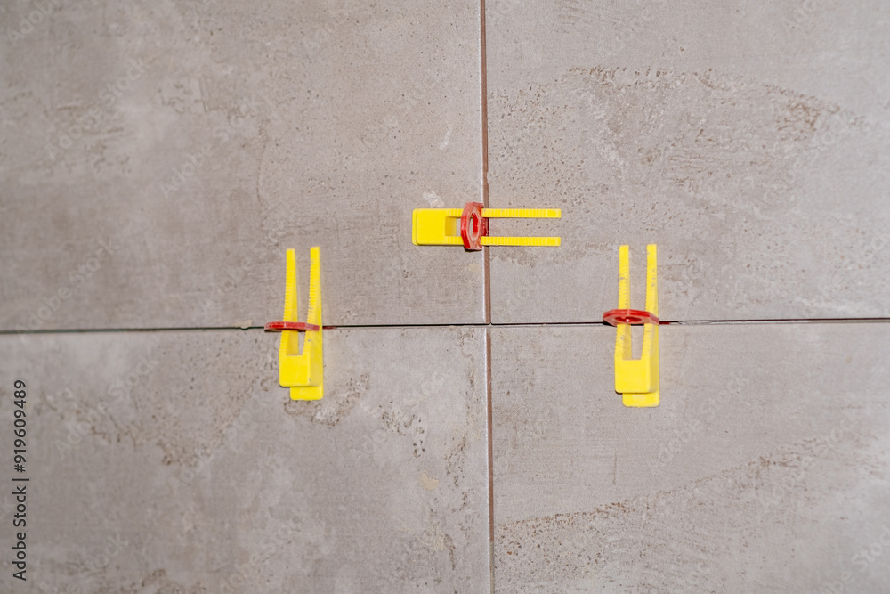 Aufkleber detailed view of tile leveling system in use with plastic clips and wedges.