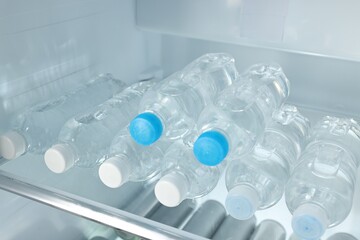 Many bottles of water in refrigerator, closeup