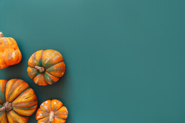 Artificial pumpkins on a green background.