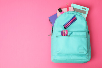 Backpack and different school supplies on pink background, top view. Space for text