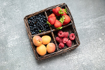 summer fruits in basket on dark background. close-up, place for text