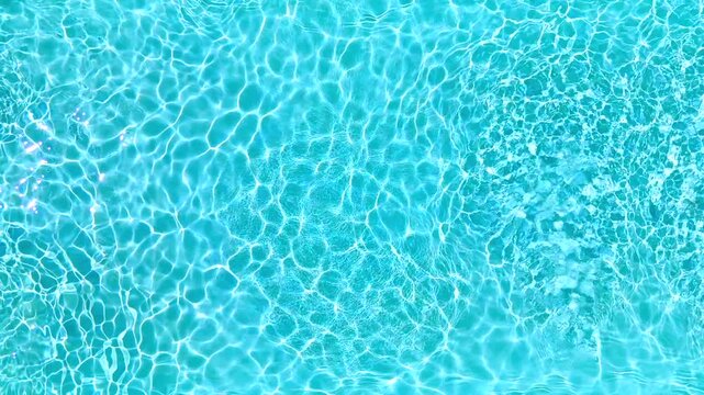 Blue water in the swimming pool with light reflections. Slow motion