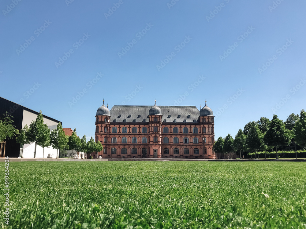 Poster a large building with a green lawn in front of it