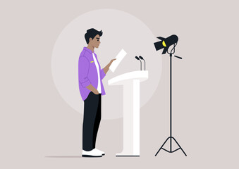 A confident individual reads from a paper while standing at a podium, focused under the spotlight and preparing to engage an audience