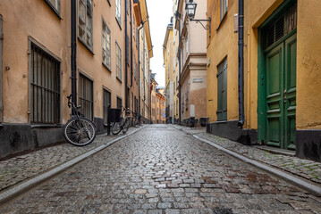 Sweden quaint cobblestone street in picturesque Gamla Stan, Stockholm's oldest neighborhood. Parked...