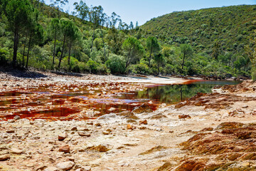 Rio Tinto river and iron mines. Red tinted river by copper, iron on the ground. Water used in life...