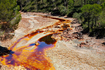 Rio Tinto river and iron mines. Red tinted river by copper, iron on the ground. Water used in life...