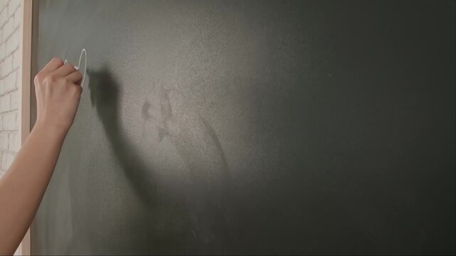 Close up of woman hand writing chemistry formulas on chalkboard, professor writes on blackboard or student solving task. Education and science concept.