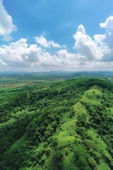 Fototapeta premium Rolling hills blanketed in lush greenery with clear blue sky in the background.