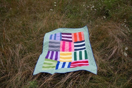 striped quilt in meadow