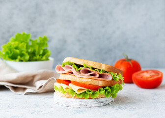 Sandwich with white bread, salad, ham and cheese on the table. Selective focus