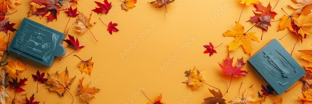Poster teal blue objects are nestled within a border of colorful autumn leaves on a vibrant yellow backgrou