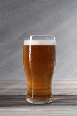 Glass of beer on grey wooden table