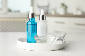 Peeling procedure. Bottles of chemical peel, bowl with liquid and brush on white table indoors