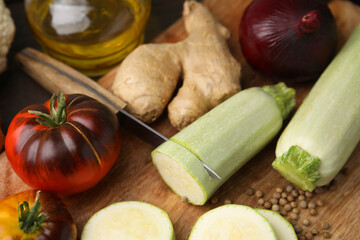 Cooking vegetable stew. Fresh zucchini, tomatoes, ginger and knife on table