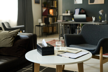 Bright and inviting living room featuring comfortable seating and a white round coffee table adorned with books