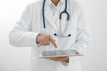 Doctor with tablet on white background, closeup view