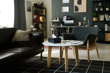 Cozy living room featuring a small office space with bookshelves, a modern table and chairs. Neutrally toned furniture creates a warm, inviting atmosphere without being overly formal